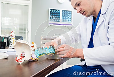 Doctor show polyaxial screw on the spine model. Spine fixation systems Stock Photo