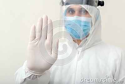 Doctor show sign Stop gesture NO to pandemic of Covid-19, Coronavirus wearing protection suit and face mask on white background. Stock Photo