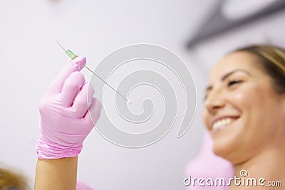 Doctor showing a PDO treatment suture thread to her patient. Stock Photo