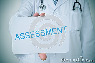 Doctor showing a signboard with the word assessment Stock Photo