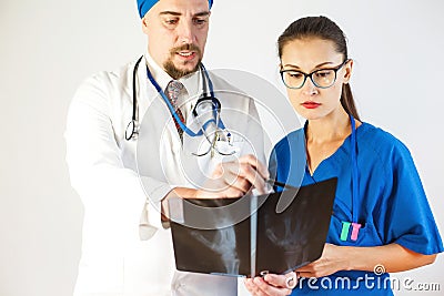 The doctor shows a colleague an x-ray, they discuss the problem. White background Stock Photo