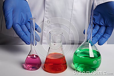 Doctor Scientist Shows Colored Chemical Flasks - Labs Photo Stock Photo