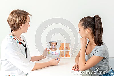 The doctor shows the patient a brochure about the thyroid gland and its functions Editorial Stock Photo