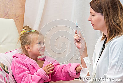 Doctor shows the syringe little girl Stock Photo