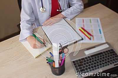 Doctor sits in a medical office in the clinic and writes medical Stock Photo