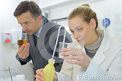 Doctor smells liquid while assistant looking Stock Photo