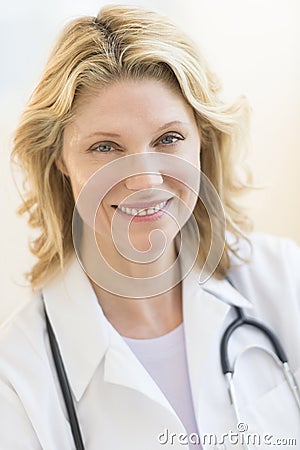 Doctor With Stethoscope Around Neck Smiling In Hospital Stock Photo