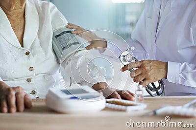 Doctor with stethoscope taking care and checking blood pressure of elderly woman patients in hospital, elderly healthcare Stock Photo