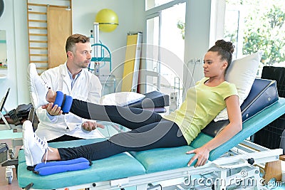 Doctor stretching woman leg on physiotherapy session Stock Photo