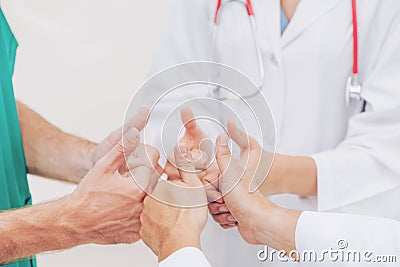 Doctor, surgeon and nurse join hands together Stock Photo