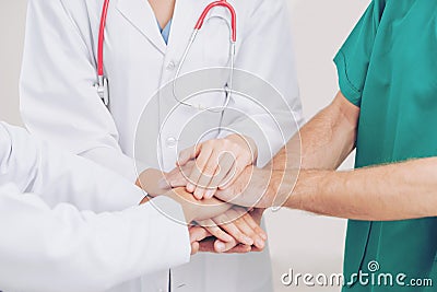 Doctor, surgeon and nurse join hands together Stock Photo