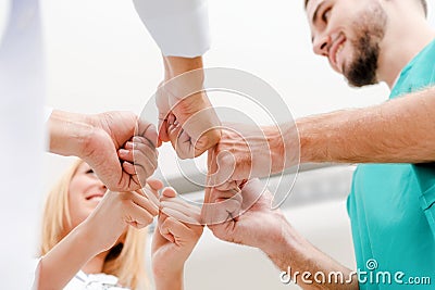 Doctor, surgeon and nurse join hands together. Stock Photo