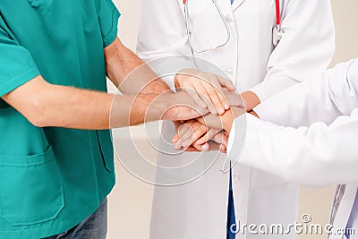 Doctor, surgeon and nurse join hands together. Stock Photo