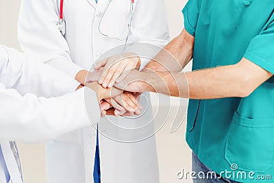 Doctor, surgeon and nurse join hands together. Stock Photo