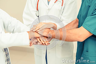 Doctor, surgeon and nurse join hands together. Stock Photo