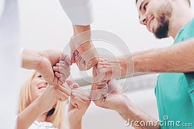 Doctor, surgeon and nurse join hands together. Stock Photo