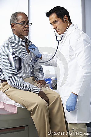 Doctor In Surgery Listening To Male Patient's Chest Stock Photo