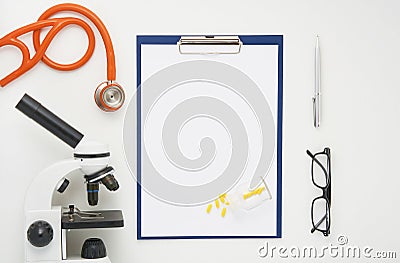Doctor table with microscope, stethoscope and glasses, top view Stock Photo