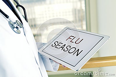 Doctor and tablet wit the text flu season Stock Photo