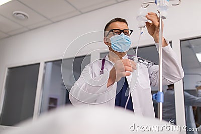 Doctor take care or look after patient by himself. Doctor checking Intravenous drip, I.V. tube saline fluid bag for cure patient Stock Photo