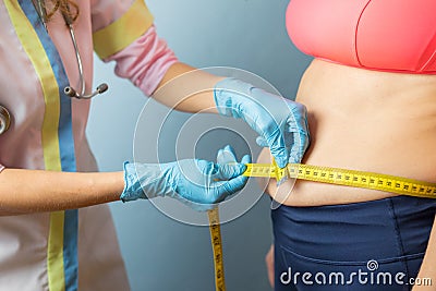 Doctor taking obese woman`s body fat measurements Stock Photo