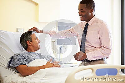 Doctor Talking To Male Patient In Hospital Room Stock Photo