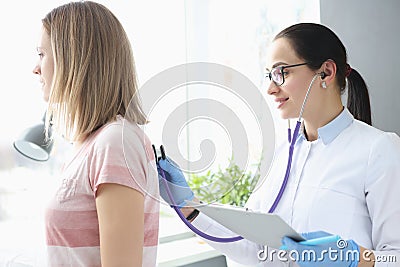 Doctor therapist listens to patient& x27;s lungs with stethoscope Stock Photo