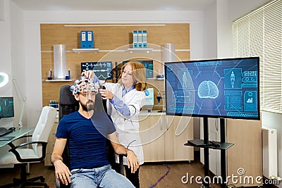 Doctor tracking data transmitted by brainwaves scanning headset Stock Photo