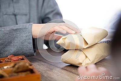 The doctor of traditional Chinese medicine gives the patient the prepared traditional Chinese medicine Stock Photo