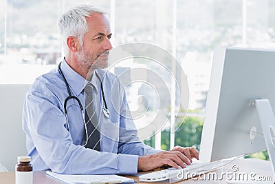 Doctor typing on his computer Stock Photo