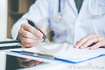 Doctor typing information working in Hospital office focus on St Stock Photo