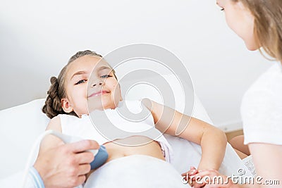 Doctor ultrasound examines little girl belly Stock Photo