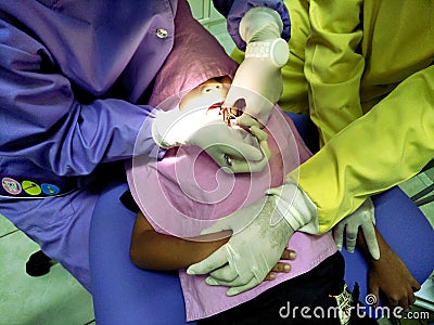 Doctor in uniform checking up Dentist examining kid`s teeth at dental clinic Editorial Stock Photo