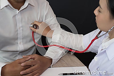 Doctor use stethoscope to examine pulse rate on patient chest at Stock Photo