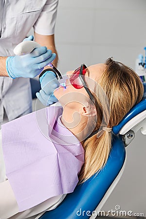 Doctor using dental curing light for fixing composite resin Stock Photo