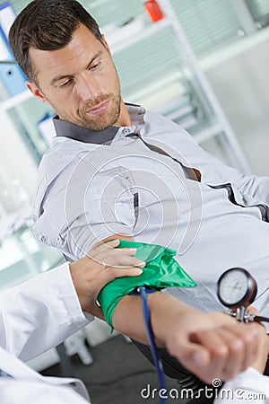 Doctor using sphygmomanometer to check blood pressure Stock Photo