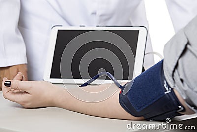 Doctor Using a Tablet in a Clinic with a Patient Stock Photo