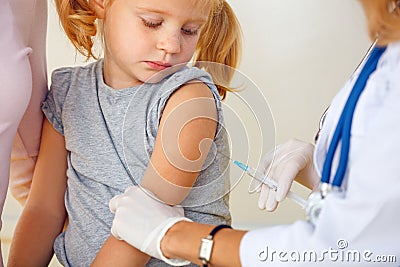 Doctor vaccinating small girl Stock Photo
