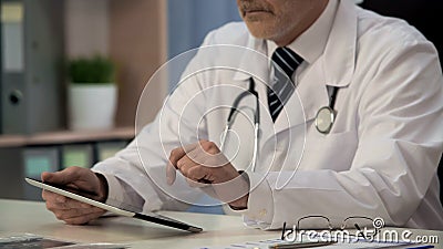 Doctor viewing medical app on tablet, innovations in health care services Stock Photo