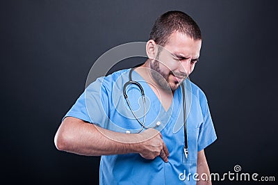 Doctor wearing scrubs having suffering stomach ache Stock Photo