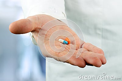 Doctor in a white labcoat giving pills Stock Photo