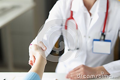 Doctor woman greet patient and shake hand, medical worker in uniform Stock Photo