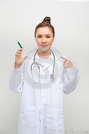 Doctor woman holding syringe with hand pointing, shocked with shame and surprise face, angry and frustrated. Fear and upset for Stock Photo