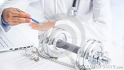 A doctor woman in surgeries prescribes sport movement and weight loss using dumbbells and a measuring tape Stock Photo