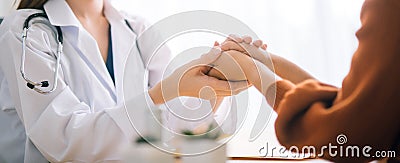 Doctor woman holding hand for reassuring her female patient. Stock Photo