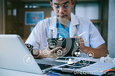 Doctor working on tablet and laptop computer and medical stethoscope on clipboard on desk, electronics medical record system EMRs Stock Photo