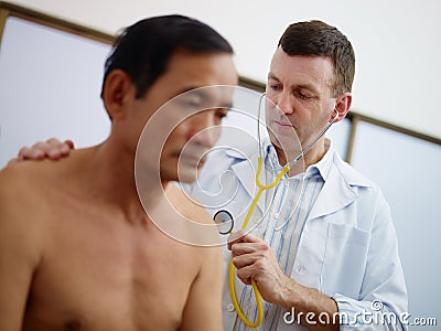 Doctor working and visiting old man in clinic Stock Photo