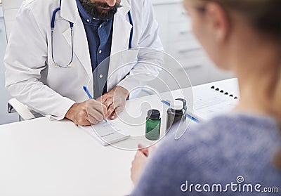 The doctor writes a prescription medicine to the patient Stock Photo