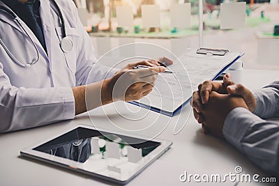 Doctor is writing the appointment letter to the patient at the clinic Stock Photo