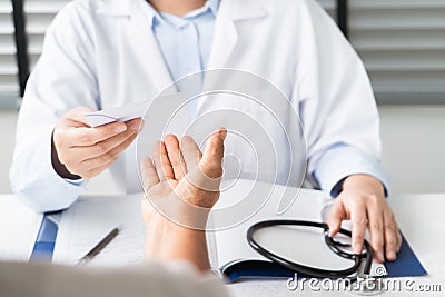 Doctor writing diagnosis and giving a medical prescription to senior women Patient Stock Photo